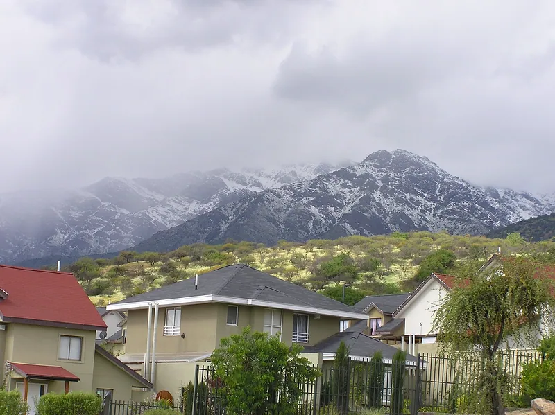 Casas de Alto Macul, en La Florida, al pie de la precordillera con nieve en un día nublado