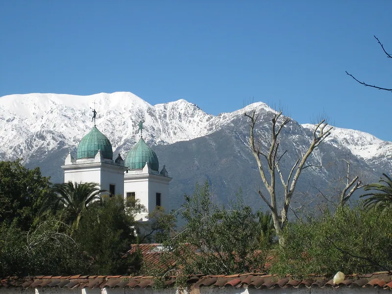 Torres de la iglesia de Los Dominicos, en Las Condes, frente a la cordillera nevada