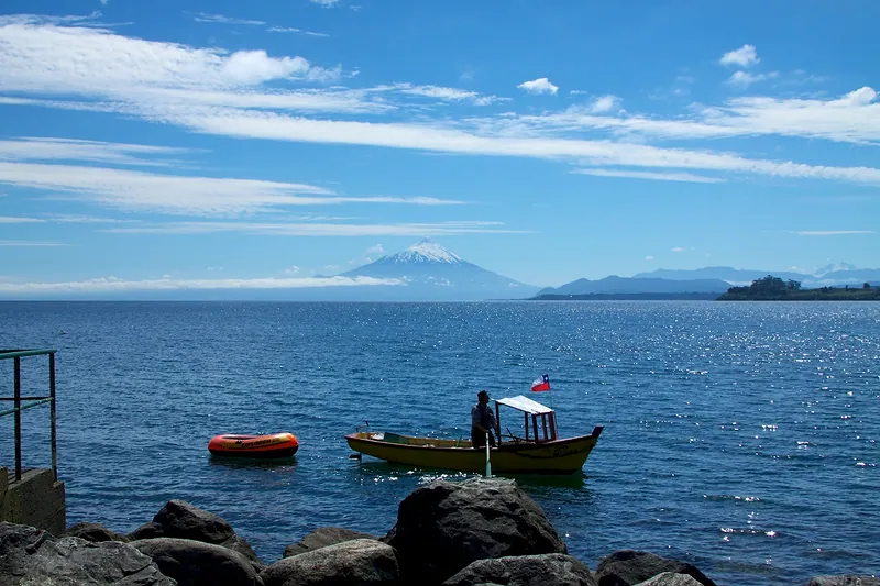 Lago Llanquihue desde la costanera de Puerto Varas, con un bote y el volcán Osorno al fondo