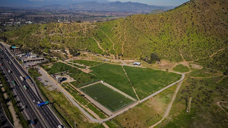 Vista aérea del cerro Chena, en San Bernardo, con las canchas del parque a sus pies y la autopista a un costado