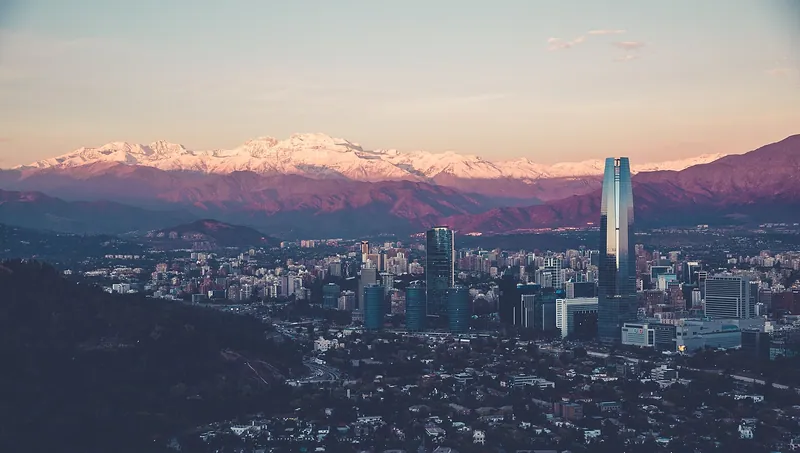Santiago al atardecer: los edificios del sector oriente y la cordillera de los Andes nevada al fondo